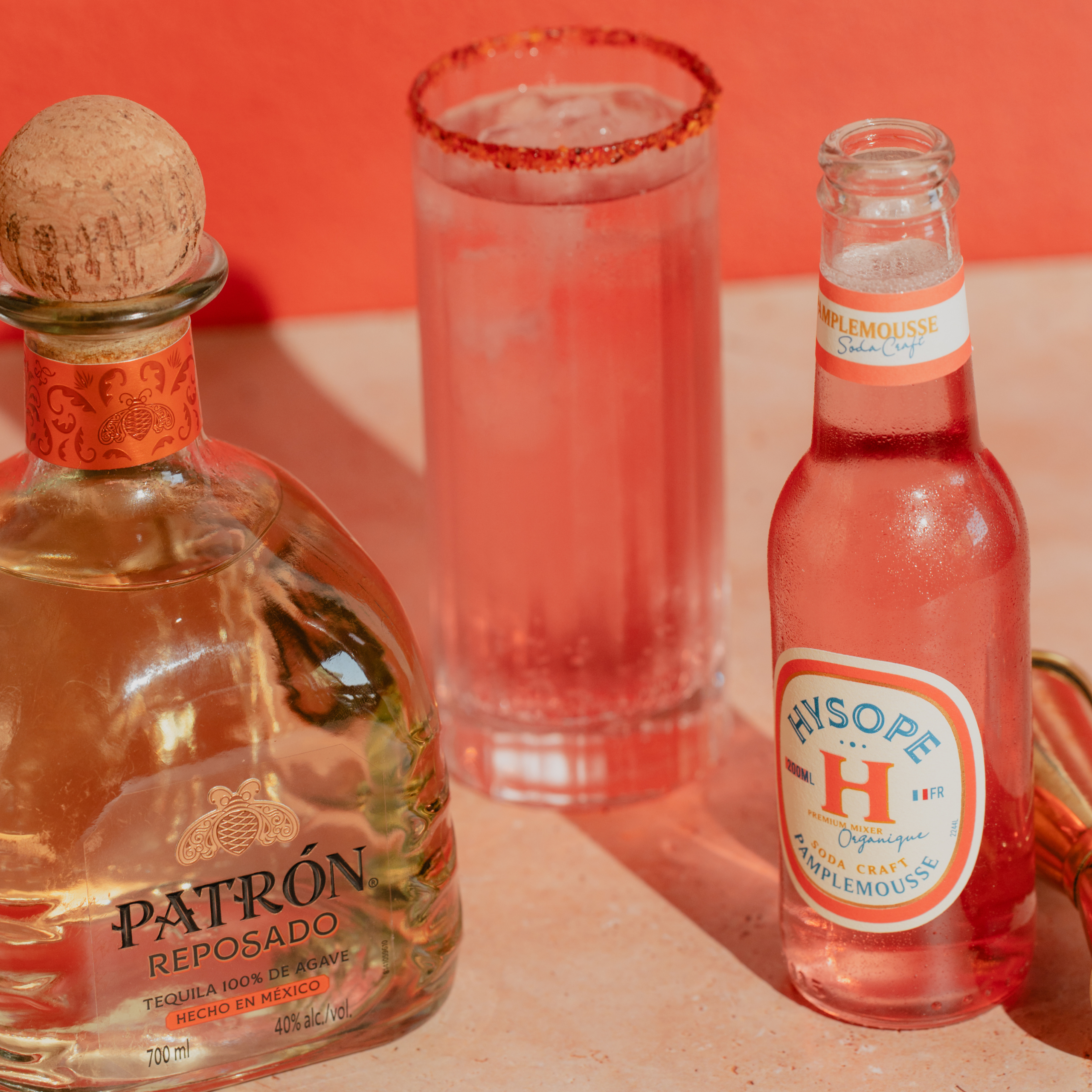 Bouteille de tequila Patrón Reposado, soda Hysope pamplemousse et verre de cocktail Paloma rimé au piment